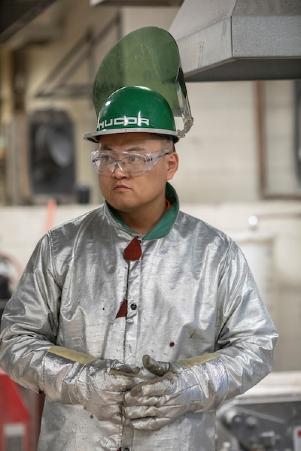 A male student in foundry safety gear